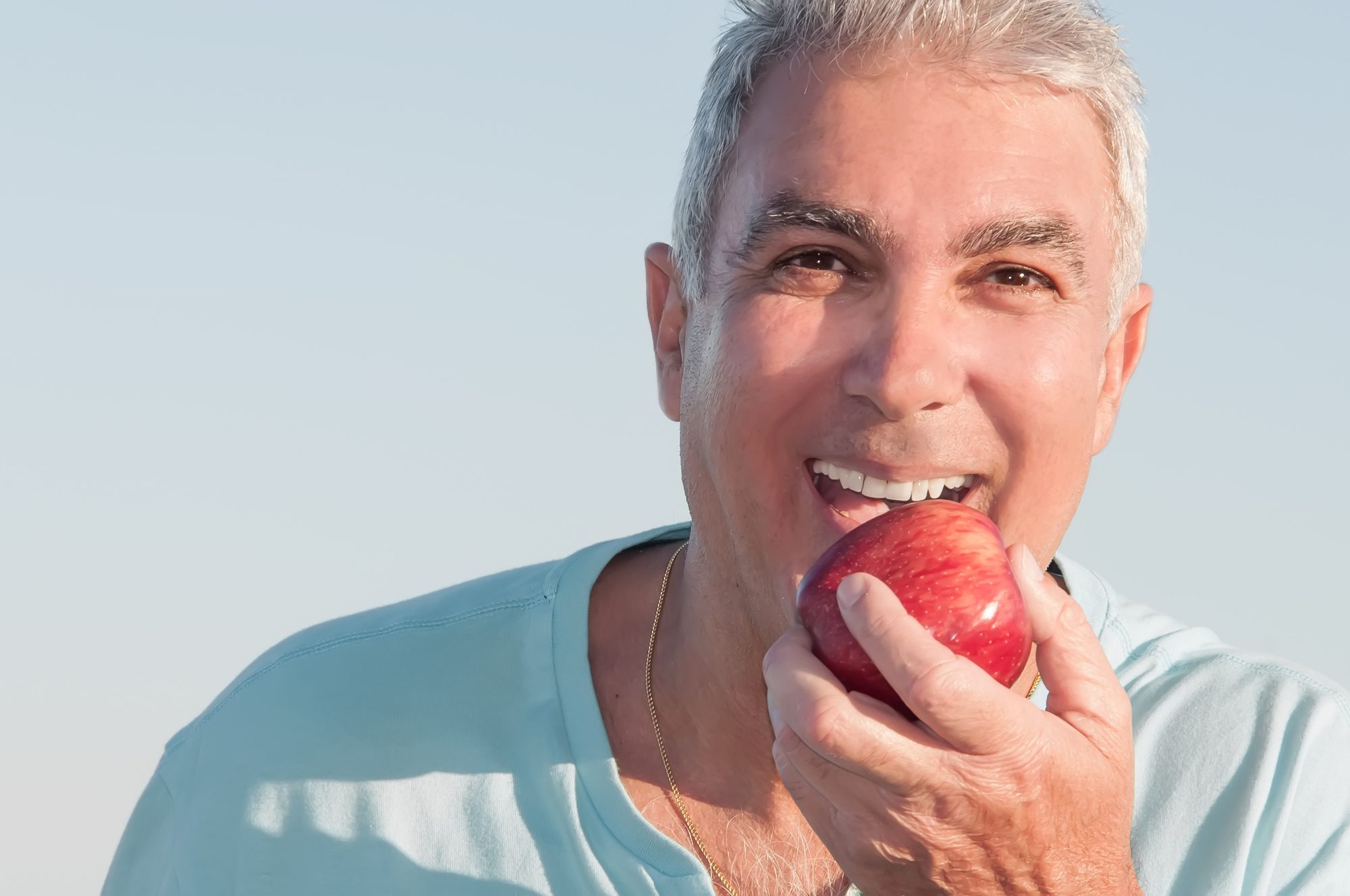 Older man eating an apple